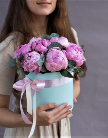 9 розовых пионов в шляпной коробке с зеленью